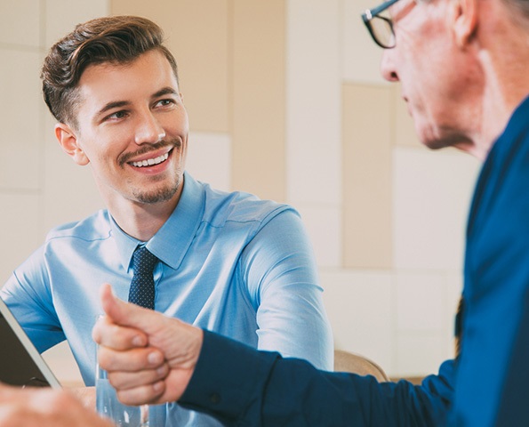 Smiling Businessman Listening to Senior Man Smiling Businessman Listening to Senior Man