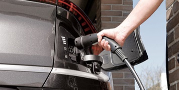 Man-charging-his-grey-electric-vehicle