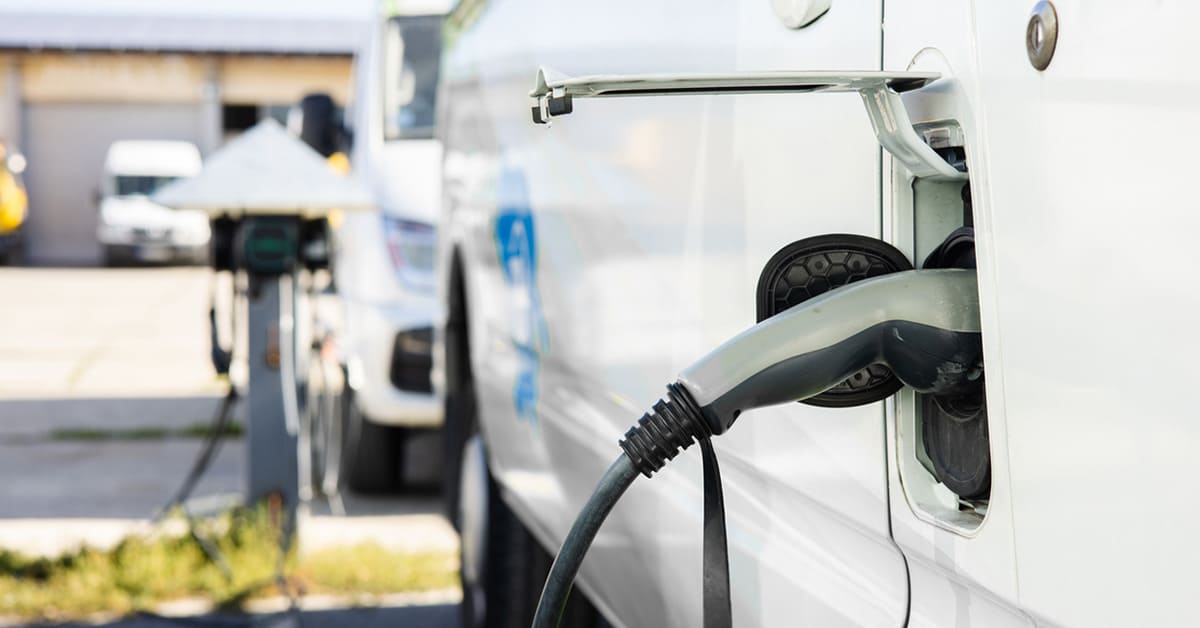 An electric vehicle connected to a charging station, illustrating the transition to sustainable energy solutions.