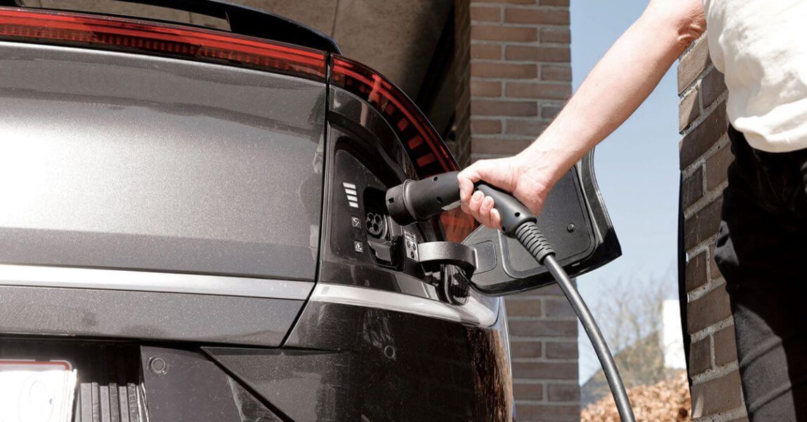 Man charging EV at home