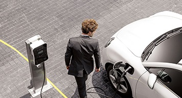 man-looking-back-at-his-white-electric-vehicle-car man-looking-back-at-his-white-electric-vehicle-car