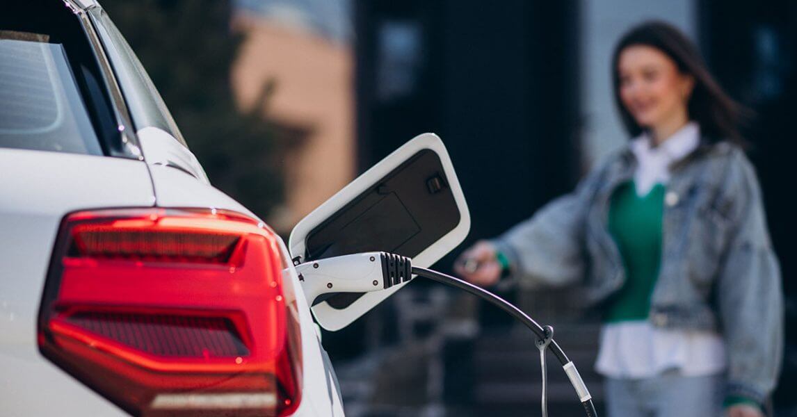 Happy lady charging her EV