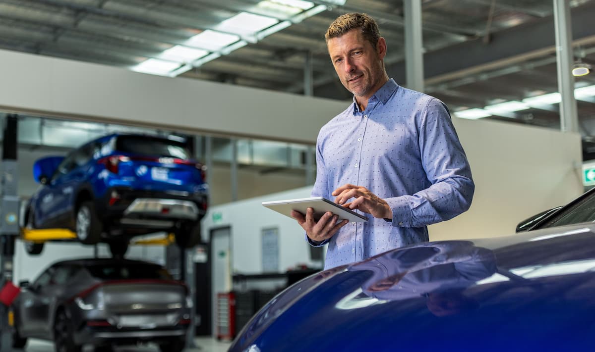 Person using a tablet in an automotive workshop