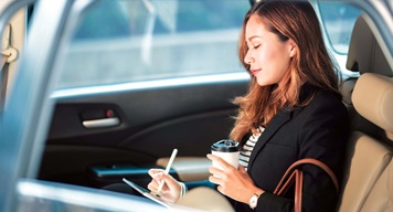 SGF_Onward_People_RGB_LR_66-medium Woman in backseat of car with coffee and a tablet