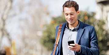 Man walking outside looking at his phone