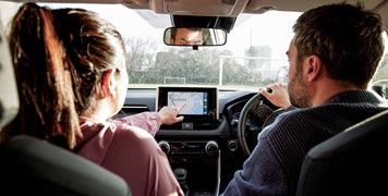 Couple driving a car looking at GPS