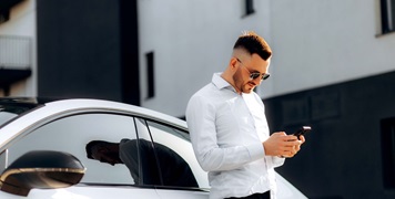 Man leaning on car on phone