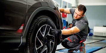 Auto specialist checking car tyres